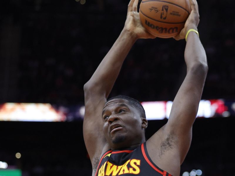 HOUSTON, TEXAS - DECEMBER 20: Clint Capela #15 of the Atlanta Hawks drives to the net ahead of Jabari Smith Jr. #10 of the Houston Rockets during the first half at Toyota Center on December 20, 2023 in Houston, Texas. User expressly acknowledges and agrees that, by downloading and or using this photograph, User is consenting to the terms and conditions of the Getty Images License Agreement.?  (Photo by Carmen Mandato/Getty Images)