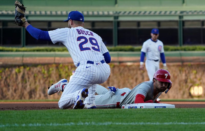 Apr 27, 2025; Chicago, Illinois, USA; Philadelphia Phillies shortstop Trea Turner (7) dives back into first base as Chicago Cubs first base Michael Busch (29) takes a throw during the first inning at Wrigley Field. Mandatory Credit: David Banks-Imagn Images