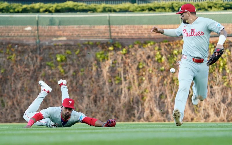 Apr 27, 2025; Chicago, Illinois, USA; Philadelphia Phillies outfielder Johan Rojas (left) and outfielder Nick Castellanos (8) can’t catch a double hit by Chicago Cubs second base Nico Hoerner (not pictured) during the second inning at Wrigley Field. Mandatory Credit: David Banks-Imagn Images