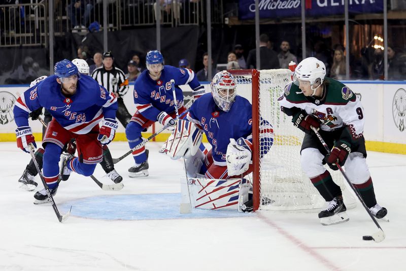 Oct 16, 2023; New York, New York, USA; Arizona Coyotes right wing Clayton Keller (9) plays the puck against New York Rangers defensemen Ryan Lindgren (55) and Jacob Trouba (8) and goaltender Igor Shesterkin (31) during the third period at Madison Square Garden. Mandatory Credit: Brad Penner-USA TODAY Sports