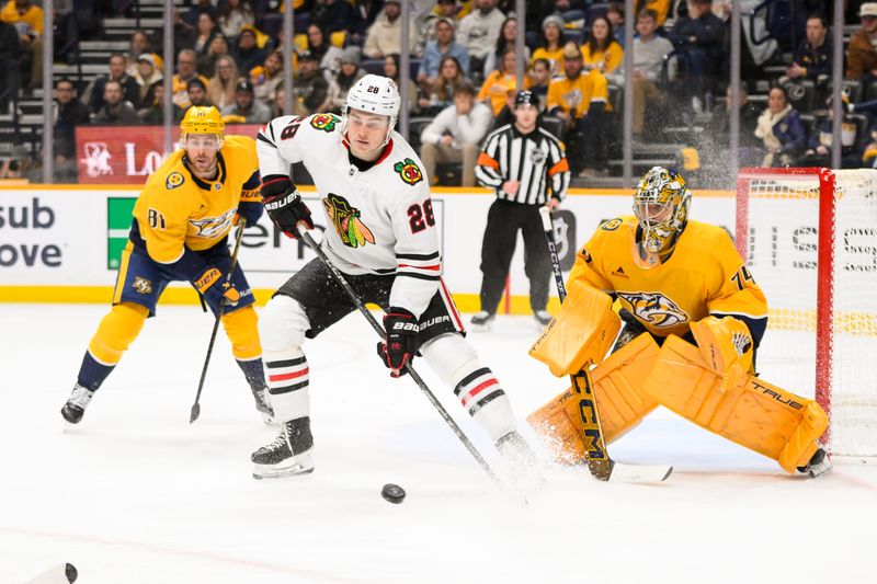 Jan 16, 2025; Nashville, Tennessee, USA;  Nashville Predators goaltender Juuse Saros (74) blocks the deflection of Chicago Blackhawks center Colton Dach (28) during the second period at Bridgestone Arena. Mandatory Credit: Steve Roberts-Imagn Images