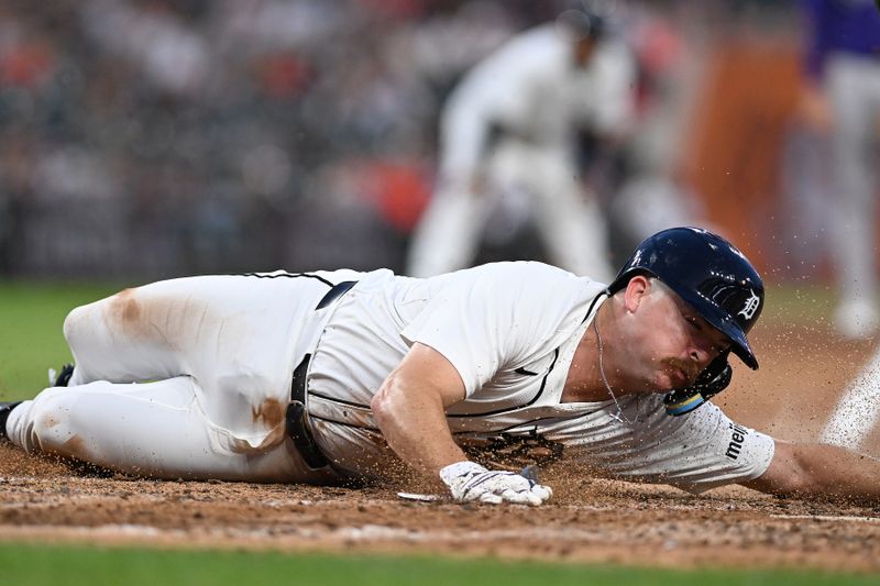 Sep 11, 2024; Detroit, Michigan, USA; Detroit Tigers catcher Jake Rogers (34) slides safely into home plate to score a run on a sacrifice fly by left fielder Riley Greene (not pictured) against the Colorado Rockies in the fourth inning at Comerica Park. Mandatory Credit: Lon Horwedel-Imagn Images