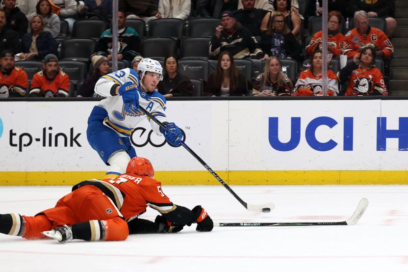 Mar 8, 2026; Anaheim, California, USA;  St. Louis Blues left wing Jake Neighbours (63) shoots the puck as Anaheim Ducks defenseman Olen Zellweger (51) defends during the first period at Honda Center. Mandatory Credit: Kiyoshi Mio-Imagn Images