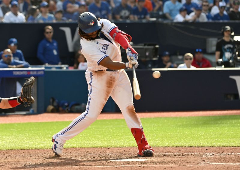 May 13, 2023; Toronto, Ontario, CAN; Toronto Blue Jays first baseman Vladimir Guerrero Jr. (27) hits a sacrifice fly ball to score a run against the Atlanta Braves in the seventh  inning at Rogers Centre. Mandatory Credit: Dan Hamilton-USA TODAY Sports