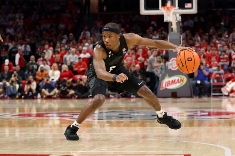 Jan 3, 2025; Columbus, Ohio, USA;  Michigan State Spartans guard Tre Holloman (5) dribbles the ball during the first half against the Ohio State Buckeyes at Value City Arena. Mandatory Credit: Joseph Maiorana-Imagn Images