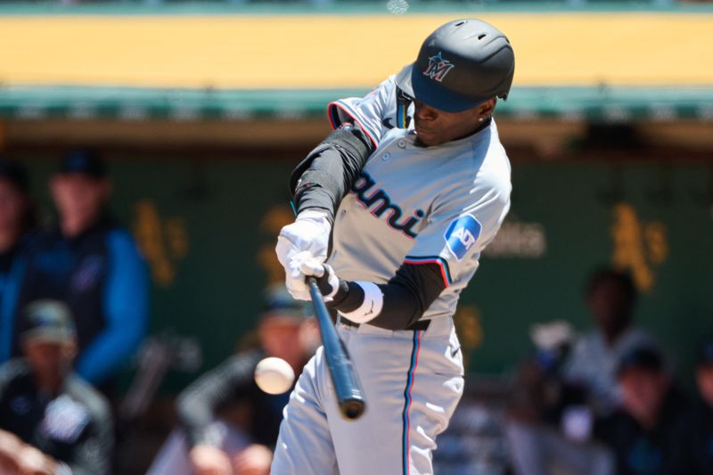 May 5, 2024; Oakland, California, USA; Miami Marlins outfielder Nick Gordon (1) hits a single against the Oakland Athletics during the third inning at Oakland-Alameda County Coliseum. Mandatory Credit: Robert Edwards-USA TODAY Sports