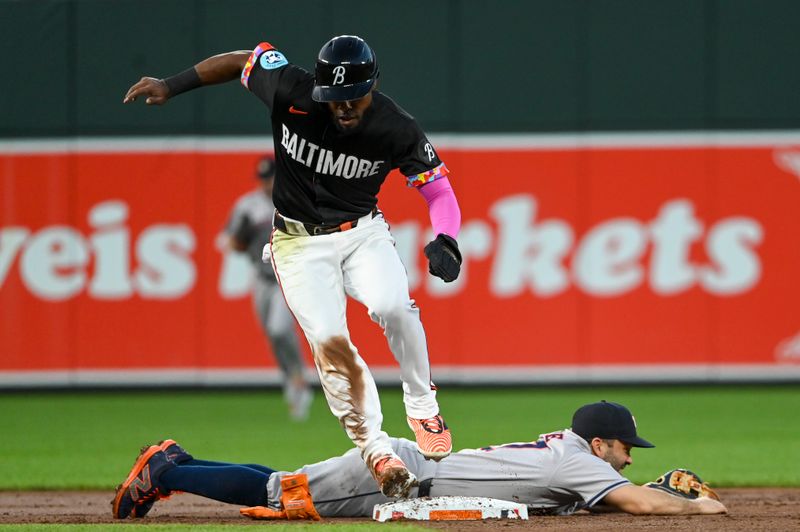 Aug 23, 2024; Baltimore, Maryland, USA;  Baltimore Orioles center fielder Cedric Mullins (31) leaps over Houston Astros second baseman Jose Altuve (27) on a second inning throwing error at Oriole Park at Camden Yards. Mandatory Credit: Tommy Gilligan-USA TODAY Sports