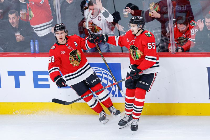 Nov 18, 2025; Chicago, Illinois, USA; Chicago Blackhawks center Connor Bedard (98) celebrates with defenseman Artyom Levshunov (55) after scoring against the Calgary Flames during the third period at United Center. Mandatory Credit: Kamil Krzaczynski-Imagn Images