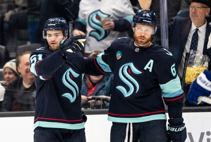 Jan 29, 2026; Seattle, Washington, USA; Seattle Kraken forward Shane Wright (51) and defenseman Adam Larsson (6) celebrate a goal during the second period at Climate Pledge Arena. Mandatory Credit: Stephen Brashear-Imagn Images