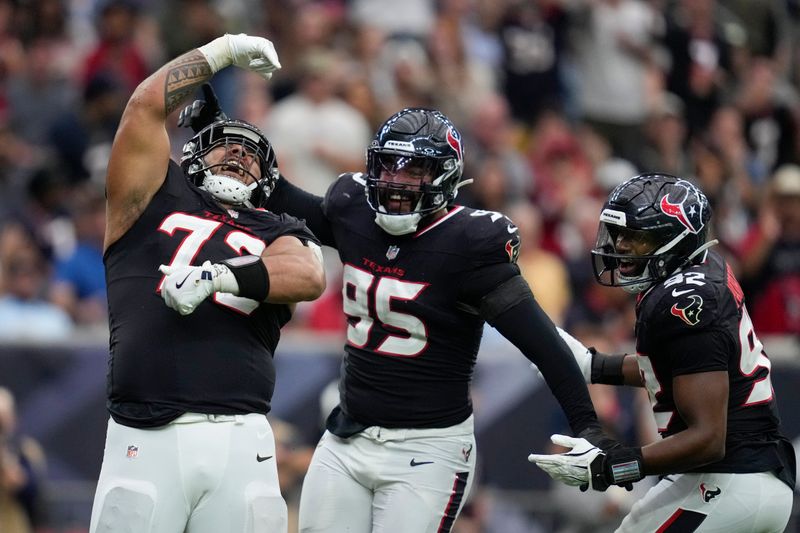 Houston Texans defensive tackle Tommy Togiai (72) celebrates his sack with teammates Derek Barnett (95) and Dylan Horton (92) during the second half an NFL football game against the Tennessee Titans, Sunday, Nov. 24, 2024, in Houston. (AP Photo/Ashley Landis)