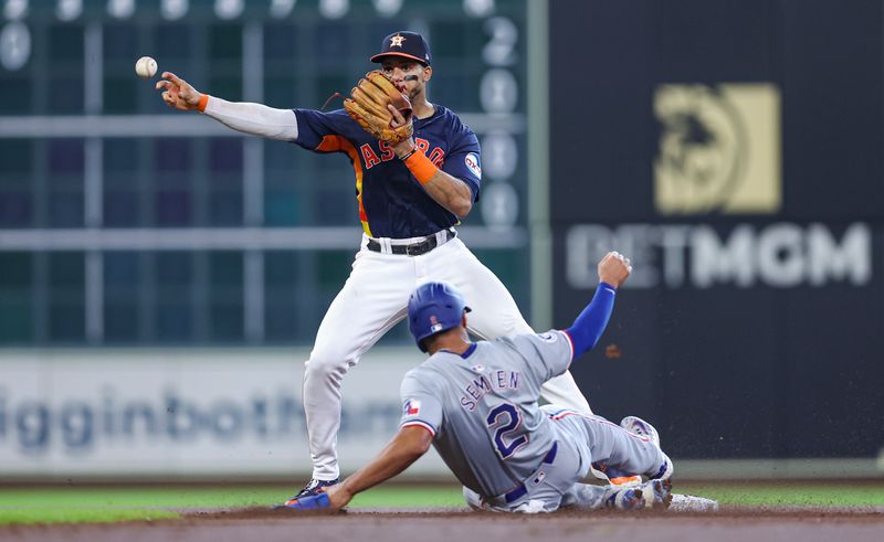 Jul 14, 2024; Houston, Texas, USA; Texas Rangers second baseman Marcus Semien (2) is out at second base as Houston Astros shortstop Jeremy Pena (3) throws to first base during the first inning at Minute Maid Park. Mandatory Credit: Troy Taormina-USA TODAY Sports