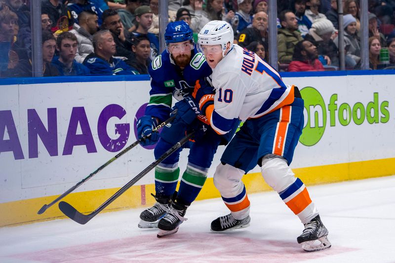 Nov 14, 2024; Vancouver, British Columbia, CAN; New York Islanders forward Simon Holmstrom (10) battles with Vancouver Canucks defenseman Filip Hronek (17) during the second period at Rogers Arena. Mandatory Credit: Bob Frid-Imagn Images