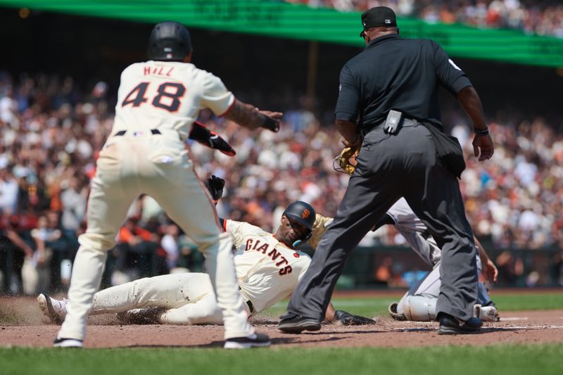 Jul 28, 2024; San Francisco, California, USA; San Francisco Giants designated hitter Jorge Soler (2) slides into home to score a run against Colorado Rockies catcher Jacob Stallings (25) (obscured) as San Francisco Giants outfielder Derek Hill (48) and home plate umpire Laz Diaz (63) watch the play during the sixth inning at Oracle Park. Mandatory Credit: Robert Edwards-USA TODAY Sports