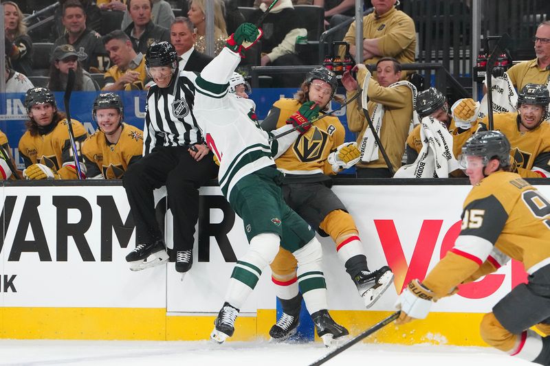 Apr 20, 2025; Las Vegas, Nevada, USA; Minnesota Wild left wing Matt Boldy (12) checks Vegas Golden Knights center William Karlsson (71) during the first period of game one of the first round of the 2025 Stanley Cup Playoffs at T-Mobile Arena. Mandatory Credit: Stephen R. Sylvanie-Imagn Images