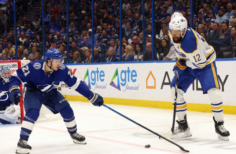 Apr 15, 2024; Tampa, Florida, USA;  Buffalo Sabres left wing Jordan Greenway (12) skates with the puck as Tampa Bay Lightning center Brayden Point (21) attempts to defend during the second period at Amalie Arena. Mandatory Credit: Kim Klement Neitzel-USA TODAY Sports