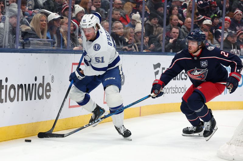 Jan 24, 2026; Columbus, Ohio, USA;  Tampa Bay Lightning defenseman Charle-Edouard D'Astous (51) controls the puck as Columbus Blue Jackets defenseman Jake Christiansen (2) defends during the first period at Nationwide Arena. Mandatory Credit: Joseph Maiorana-Imagn Images
