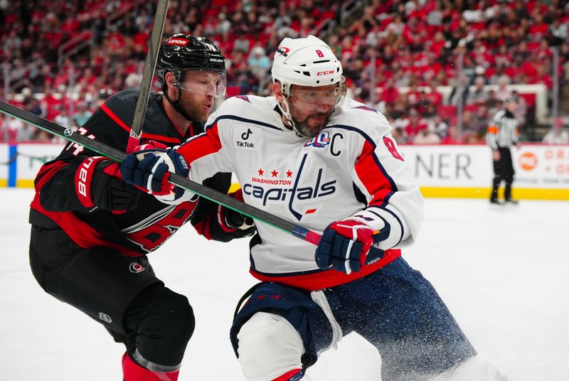 Nov 3, 2024; Raleigh, North Carolina, USA;  Washington Capitals left wing Alex Ovechkin (8) and Carolina Hurricanes defenseman Jaccob Slavin (74) battle over the puck during the second period at Lenovo Center. Mandatory Credit: James Guillory-Imagn Images