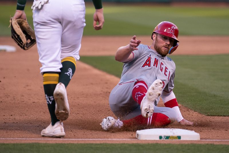 Jul 2, 2024; Oakland, California, USA; Los Angeles Angels second base Brandon Drury (23) slides into third base during the fifth inning of the game against the Oakland Athletics at Oakland-Alameda County Coliseum. Mandatory Credit: Ed Szczepanski-USA TODAY Sports