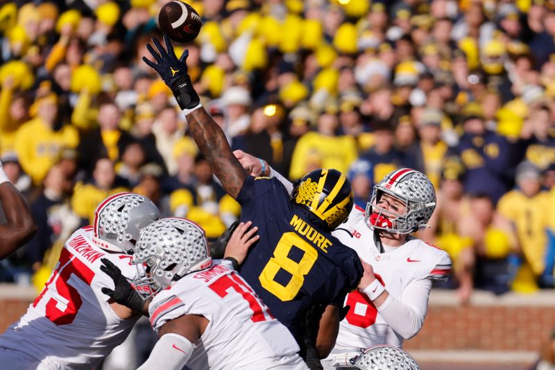 Nov 25, 2023; Ann Arbor, Michigan, USA; Ohio State Buckeyes quarterback Kyle McCord (6) passes under pressure from Michigan Wolverines defensive end Derrick Moore (8) in the first half at Michigan Stadium. Mandatory Credit: Rick Osentoski-USA TODAY Sports