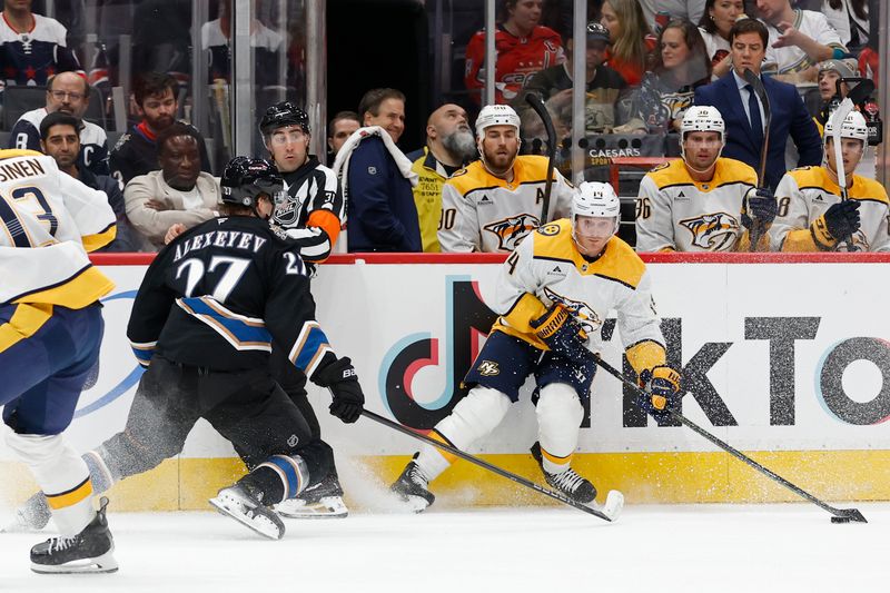 Nov 6, 2024; Washington, District of Columbia, USA; Nashville Predators center Gustav Nyquist (14) skates with the puck as Washington Capitals defenseman Alexander Alexeyev (27) in the second period at Capital One Arena. Mandatory Credit: Geoff Burke-Imagn Images