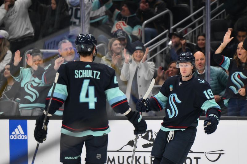 Nov 22, 2023; Seattle, Washington, USA; Seattle Kraken left wing Jared McCann (19) and defenseman Justin Schultz (4) celebrate after McCann scored a goal against the San Jose Sharks during the second period at Climate Pledge Arena. Mandatory Credit: Steven Bisig-USA TODAY Sports