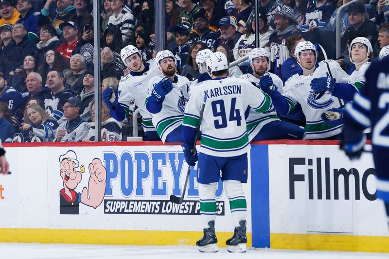 Mar 7, 2026; Winnipeg, Manitoba, CAN;  Vancouver Canucks forward Linus Karlsson (94) is congratulated by his team mates on his goal against the Winnipeg Jets during the first period at Canada Life Centre. Mandatory Credit: Terrence Lee-Imagn Images