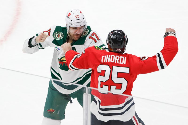 Feb 7, 2024; Chicago, Illinois, USA; Chicago Blackhawks defenseman Jarred Tinordi (25) fights with Minnesota Wild left wing Marcus Foligno (17) during the second period at United Center. Mandatory Credit: Kamil Krzaczynski-USA TODAY Sports