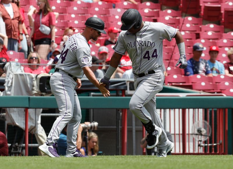 Jun 21, 2023; Cincinnati, Ohio, USA; Colorado Rockies first baseman Elehuris Montero (44) reacts with third base coach Warren Schaeffer (34) after hitting a solo home run against the Cincinnati Reds during the second inning at Great American Ball Park. Mandatory Credit: David Kohl-USA TODAY Sports