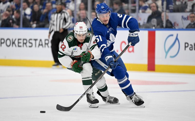 Jan 29, 2025; Toronto, Ontario, CAN;  Toronto Maple Leafs defenseman Phillipe Myers (51) clears the puck away from Minnesota Wild forward Marat Khusnutdinov (22) in the second period at Scotiabank Arena. Mandatory Credit: Dan Hamilton-Imagn Images