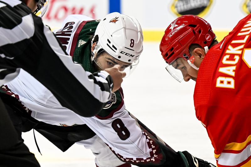 Jan 16, 2024; Calgary, Alberta, CAN; Arizona Coyotes center Nick Schmaltz (8) and Calgary Flames center Mikael Backlund (11) take a face-off during the second period at Scotiabank Saddledome. Mandatory Credit: Brett Holmes-USA TODAY Sports