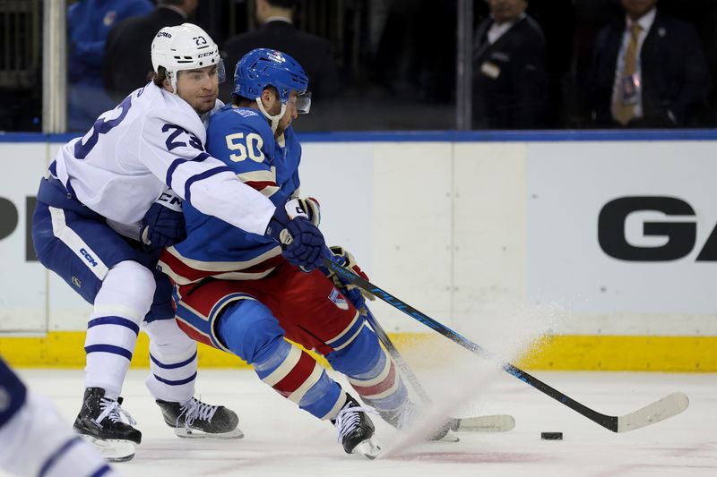 Mar 5, 2026; New York, New York, USA; Toronto Maple Leafs left wing Matthew Knies (23) and New York Rangers left wing Will Cuylle (50) fight for the puck during the second period at Madison Square Garden. Mandatory Credit: Brad Penner-Imagn Images