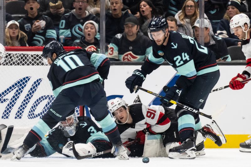 Dec 7, 2023; Seattle, Washington, USA; Seattle Kraken goalie Philipp Grubauer (31), forward Matty Beniers (10), defenseman Jamie Oleksiak (24) and New Jersey Devils forward Dawson Mercer (91) battle for the puck in front of the net during the second period at Climate Pledge Arena. Mandatory Credit: Stephen Brashear-USA TODAY Sports