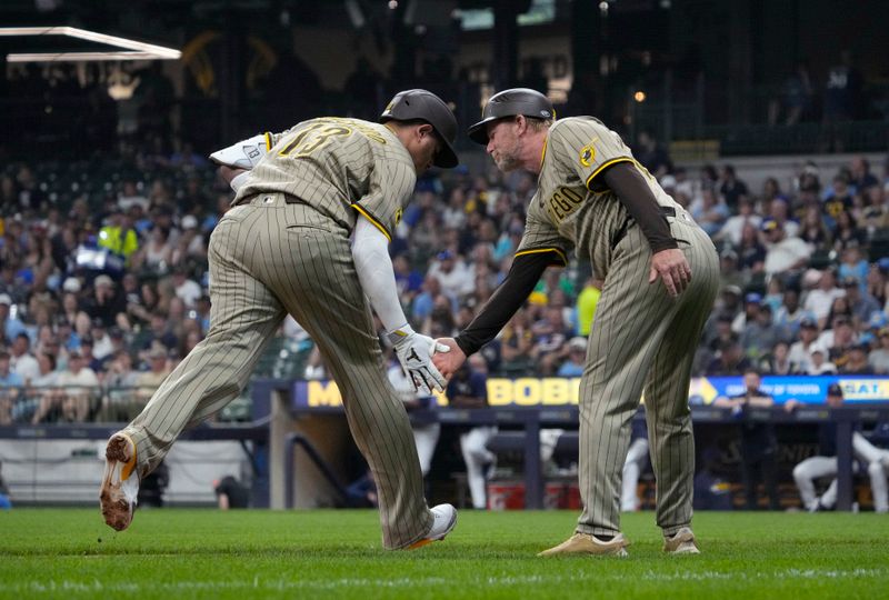 Jun 8, 2025; Milwaukee, Wisconsin, USA; San Diego Padres third base coach, infield & base running instructor Tim Leiper (33) congratulates Milwaukee Brewers catcher Eric Haase (13) after hitting a home run against the Milwaukee Brewers in the seventh inning at American Family Field. Mandatory Credit: Michael McLoone-Imagn Images