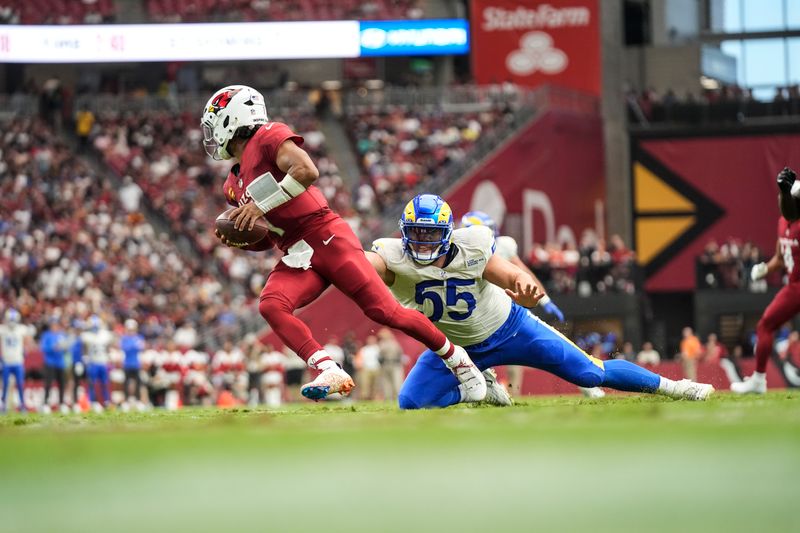 Arizona Cardinals quarterback Kyler Murray (1) leaves the pocket under pressure by Los Angeles Rams defensive tackle Braden Fiske (55) during the first half of an NFL football game, Sunday, Sept. 15, 2024, in Glendale, Ariz. (AP Photo/Ross D. Franklin)