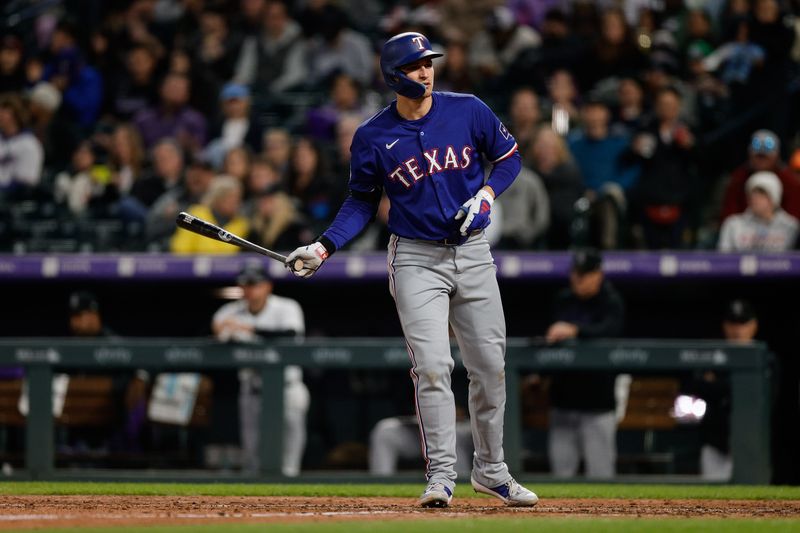 May 10, 2024; Denver, Colorado, USA; Texas Rangers shortstop Corey Seager (5) tosses his bat after being walked with the bases loaded in the seventh inning against the Colorado Rockies at Coors Field. Mandatory Credit: Isaiah J. Downing-USA TODAY Sports