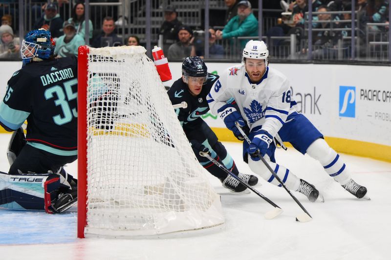 Jan 21, 2024; Seattle, Washington, USA; Toronto Maple Leafs center Noah Gregor (18) plays the puck behind the goal while defended by Seattle Kraken defenseman Ryker Evans (39) during the first period at Climate Pledge Arena. Mandatory Credit: Steven Bisig-USA TODAY Sports