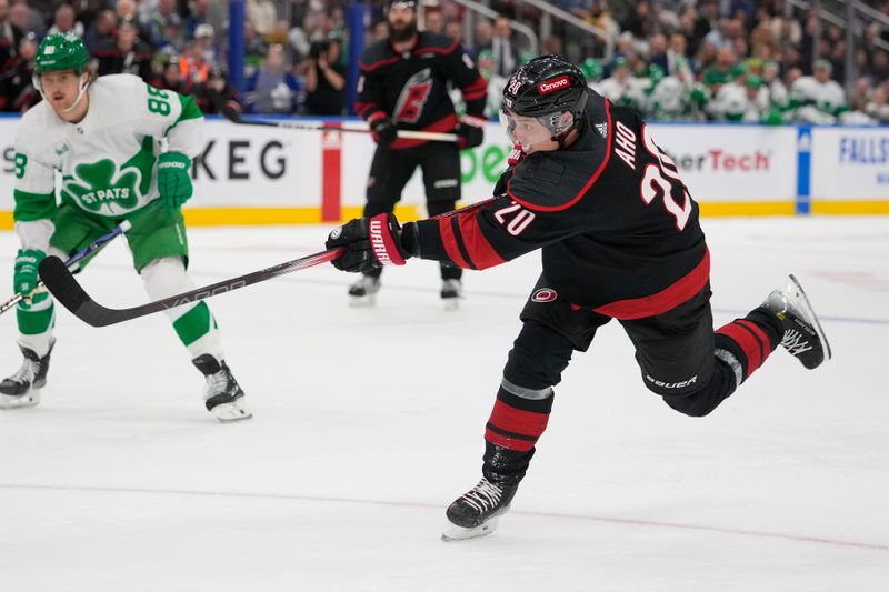 Mar 16, 2024; Toronto, Ontario, CAN; Carolina Hurricanes forward Sebastian Aho (20) shoots the puck against the Toronto Maple Leafs during the second period at Scotiabank Arena. Mandatory Credit: John E. Sokolowski-USA TODAY Sports