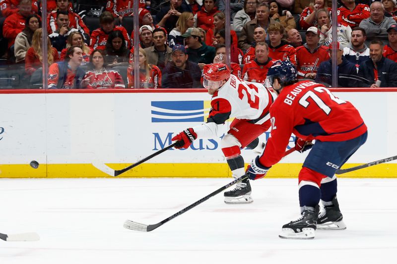 Dec 11, 2025; Washington, District of Columbia, USA; Carolina Hurricanes left wing Nikolaj Ehlers (27) shoots the puck as Washington Capitals left wing Anthony Beauvillier (72) chases during the second period at Capital One Arena. Mandatory Credit: Geoff Burke-Imagn Images