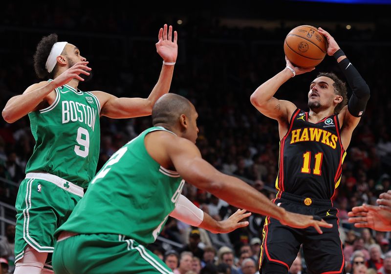 ATLANTA, GEORGIA - APRIL 21:  Trae Young #11 of the Atlanta Hawks attempts a shot against Derrick White #9 and Al Horford #42 of the Boston Celtics during the fourth quarter of Game Three of the Eastern Conference First Round Playoffs at State Farm Arena on April 21, 2023 in Atlanta, Georgia.  NOTE TO USER: User expressly acknowledges and agrees that, by downloading and or using this photograph, User is consenting to the terms and conditions of the Getty Images License Agreement.  (Photo by Kevin C. Cox/Getty Images)