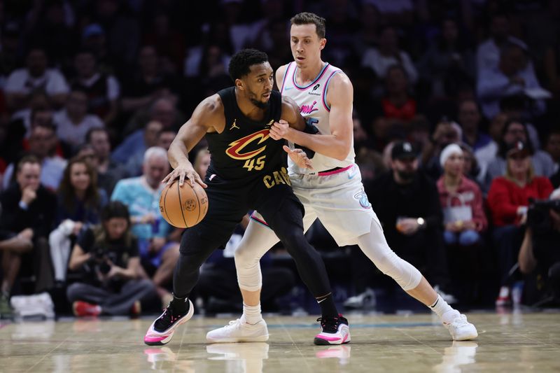 MIAMI, FLORIDA - JANUARY 29: Donovan Mitchell #45 of the Cleveland Cavaliers controls the ball around Duncan Robinson #55 of the Miami Heat during the first half at Kaseya Center on January 29, 2025 in Miami, Florida.  NOTE TO USER: User expressly acknowledges and agrees that, by downloading and or using this Photograph, user is consenting to the terms and conditions of the Getty Images License Agreement. (Photo by Carmen Mandato/Getty Images)