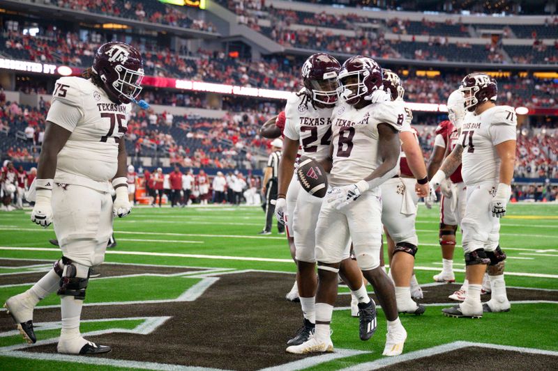 Sep 30, 2023; Arlington, Texas, USA; Texas A&M Aggies offensive lineman Kam Dewberry (75) and running back Earnest Crownover (24) and running back Le'Veon Moss (8) celebrate during the second half against the Arkansas Razorbacks at AT&T Stadium. Mandatory Credit: Jerome Miron-USA TODAY Sports