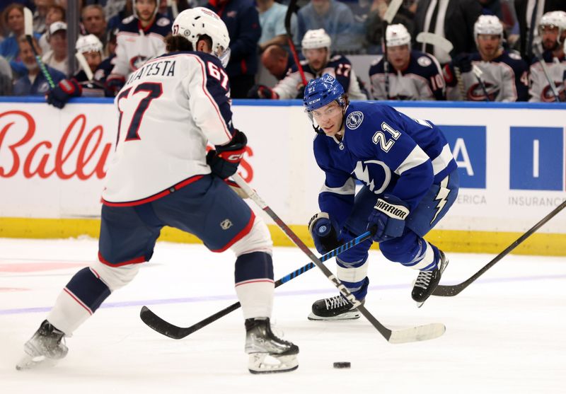 Apr 9, 2024; Tampa, Florida, USA; Tampa Bay Lightning center Brayden Point (21) defends Columbus Blue Jackets left wing James Malatesta (67) during the third period at Amalie Arena. Mandatory Credit: Kim Klement Neitzel-USA TODAY Sports