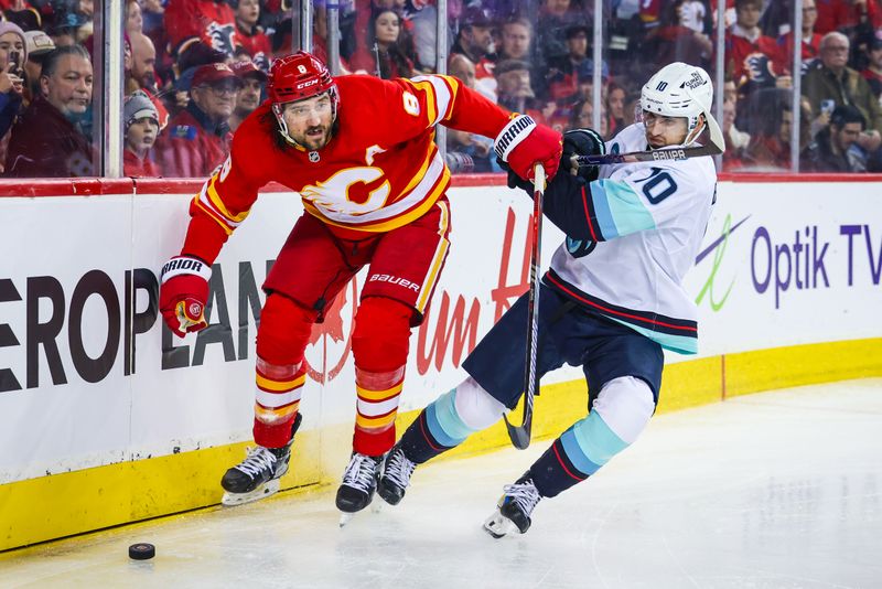 Dec 27, 2023; Calgary, Alberta, CAN; Calgary Flames defenseman Chris Tanev (8) and Seattle Kraken center Matty Beniers (10) battle for the puck during the third period at Scotiabank Saddledome. Mandatory Credit: Sergei Belski-USA TODAY Sports