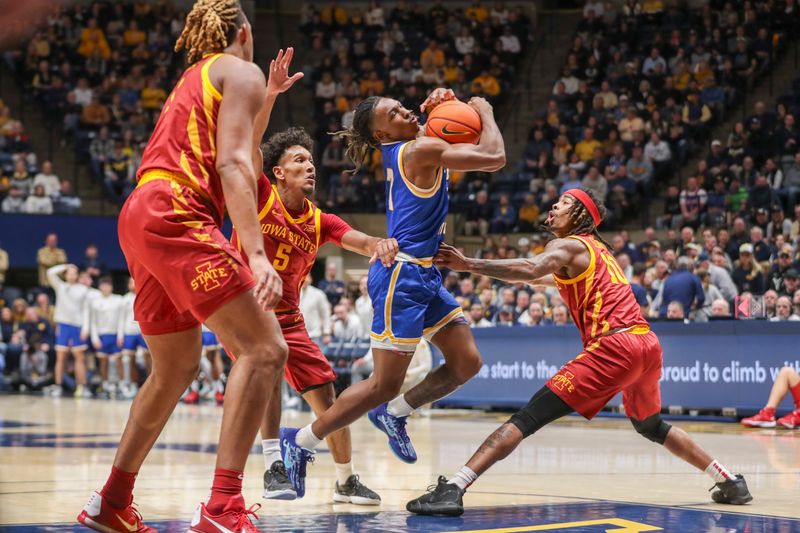 Jan 18, 2025; Morgantown, West Virginia, USA; West Virginia Mountaineers guard Javon Small (7) drives down the lane against Iowa State Cyclones guard Curtis Jones (5) and Iowa State Cyclones guard Keshon Gilbert (10) during the first half at WVU Coliseum. Mandatory Credit: Ben Queen-Imagn Images