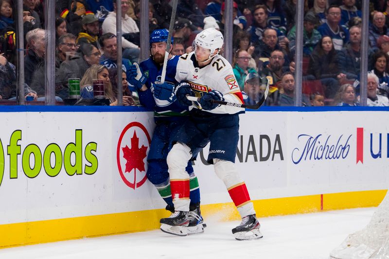 Dec 14, 2023; Vancouver, British Columbia, CAN; Florida Panthers forward Eetu Luostarinen (27) checks Vancouver Canucks defenseman Filip Hronek (17) in the second period at Rogers Arena. Mandatory Credit: Bob Frid-USA TODAY Sports