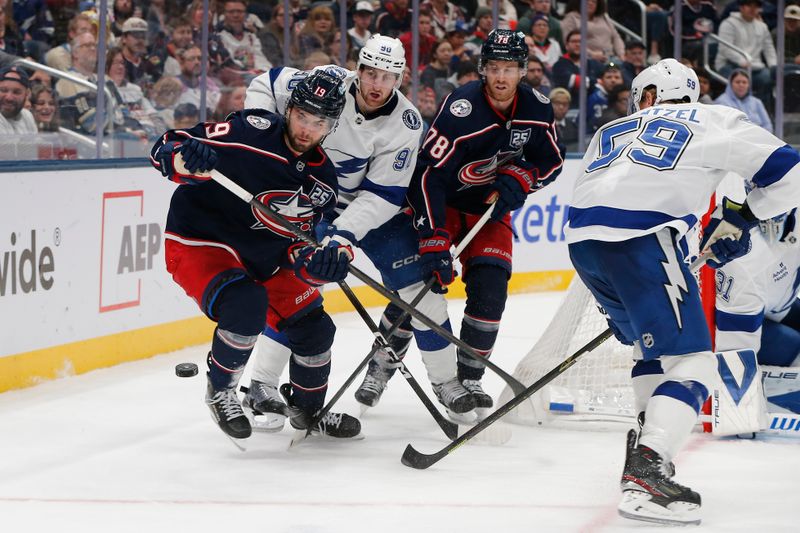 Oct 18, 2025; Columbus, Ohio, USA; Columbus Blue Jackets center Adam Fantilli (19) and Tampa Bay Lightning defenseman Janis Moser (90) skate after the puck during the second period at Nationwide Arena. Mandatory Credit: Russell LaBounty-Imagn Images