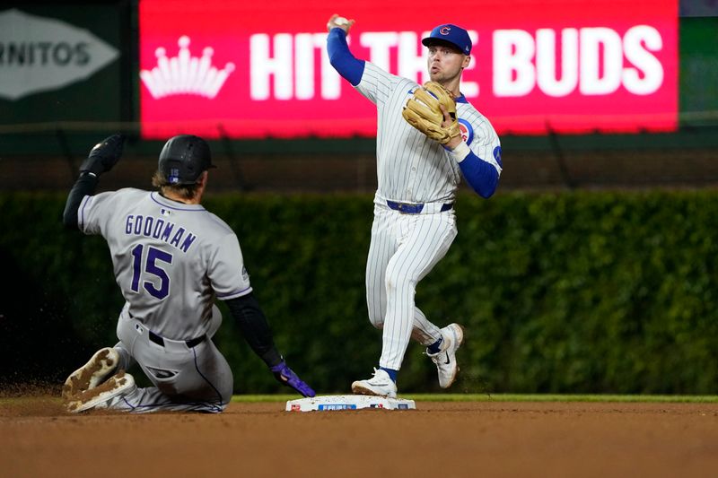 May 28, 2025; Chicago, Illinois, USA; Chicago Cubs second base Nico Hoerner (2) forces out Colorado Rockies catcher Hunter Goodman (15) at second base then throws to first base to complete a double play during the seventh inning at Wrigley Field. Mandatory Credit: David Banks-Imagn Images