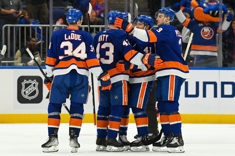 Oct 6, 2022; Elmont, New York, USA; The New York Islanders celebrate a goal scored by center Aatu Raty (43) against the New Jersey Devils during the third period at UBS Arena. Mandatory Credit: Dennis Schneidler-USA TODAY Sports