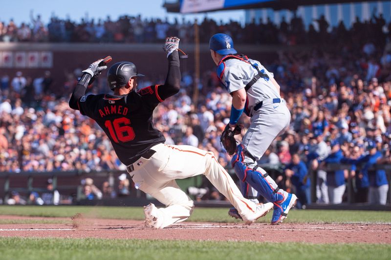 Jun 29, 2024; San Francisco, California, USA; San Francisco Giants shortstop Nick Ahmed (16) slides into home plate during the third inning against the Los Angeles Dodgers at Oracle Park. Mandatory Credit: Ed Szczepanski-USA TODAY Sports