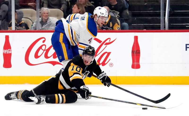 Oct 16, 2024; Pittsburgh, Pennsylvania, USA;  Buffalo Sabres defenseman Bowen Byram (4) and Pittsburgh Penguins left wing Drew O'Connor (10) battle for the puck during the first period at PPG Paints Arena. Mandatory Credit: Charles LeClaire-Imagn Images